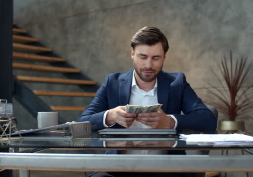 Successful business man counting money at workplace. Portrait of joyful businessman throwing money away in slow motion. Smiling man enjoy good deal at modern office. Man made easy money.